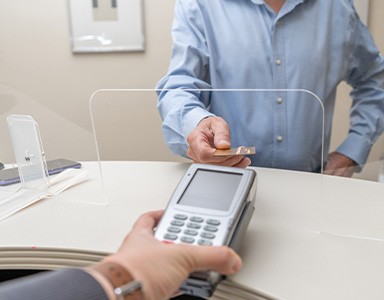 A patient using a credit card to pay the cost of cosmetic dentistry