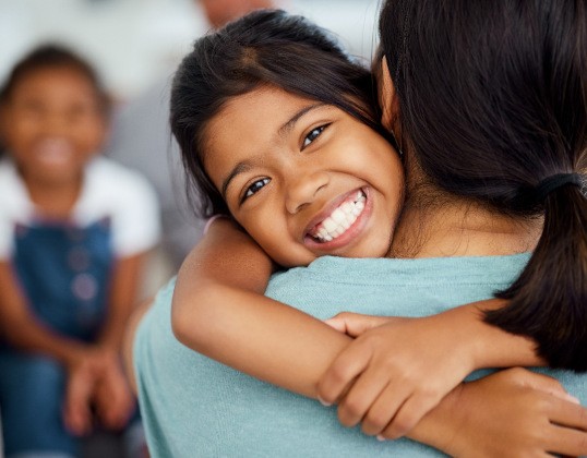 Child in Castle Rock smiling after teeth whitening